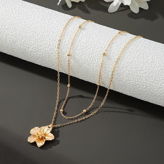 Sjika - Dames Ketting Goudkleurig met Bloem Hanger – Layered Halsketting – Dubbele Ketting Dames – Trendy Minimalistische Sieraden - Cadeau voor haar