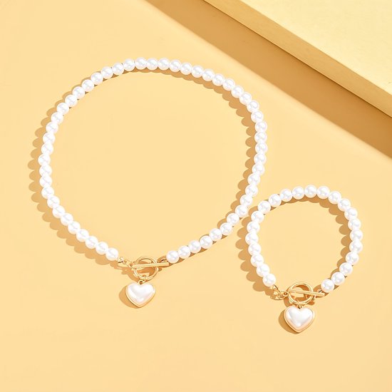 Sjika - Gold plated parelset met hart hanger – Luxe ketting & armband dames – Elegant & romantisch design – Perfect cadeau voor haar