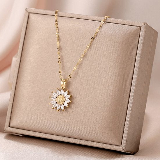 Sjika - Bloem Ketting Dames Goudkleurig – Elegante Zonnebloem Hanger met Kristal Steentjes – Luxe Dames Ketting – Trendy Sieraden - Cadeau voor haar