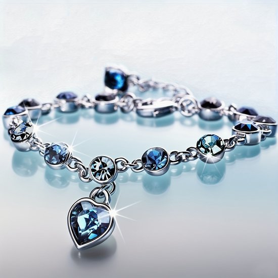 Sjika - Zilverkleurige armband met blauwe kristallen & hart hanger – Luxe damesarmband – Elegant & romantisch design – Perfect cadeau voor haar