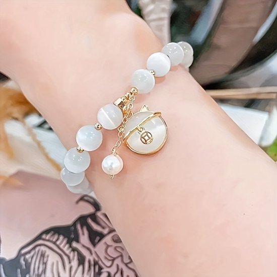 Sjika - Gold plated armband met kattenbedel & witte kralen – Uniek damesdesign – Schattig & elegant – Perfect cadeau voor haar