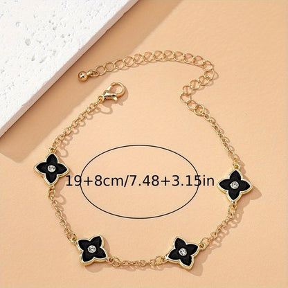 Sjika - Gold plated armband met zwarte klaver bloemen – Luxe damesarmband met kristalaccent – Trendy & Elegant sieraad – Perfect cadeau voor haar