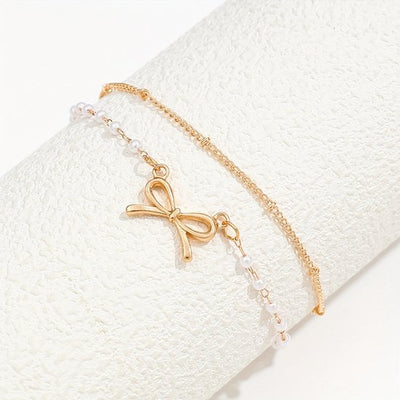 Sjika - Enkelbandje Dames Goudkleurig met Strik & Parels – Dubbele Enkelband – Trendy Zomer Enkelketting – Boho Voetsieraad - Cadeau voor haar