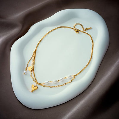 Sjika - Gold plated dubbele ketting met parels & hart hanger – Luxe damesketting – Elegant & trendy design – Perfect cadeau voor haar