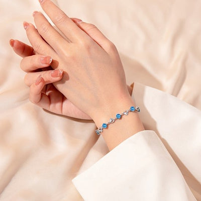 Sjika - Zilverkleurige armband met blauwe kristallen & hartjes – Luxe damesarmband – Elegant & romantisch design – Perfect cadeau voor haar