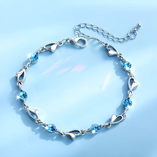 Sjika - Zilverkleurige armband met blauwe kristallen & hartjes – Luxe damesarmband – Elegant & romantisch design – Perfect cadeau voor haar