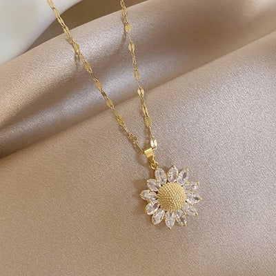 Sjika - Bloem Ketting Dames Goudkleurig – Elegante Zonnebloem Hanger met Kristal Steentjes – Luxe Dames Ketting – Trendy Sieraden - Cadeau voor haar