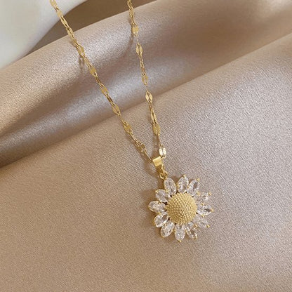 Sjika - Bloem Ketting Dames Goudkleurig – Elegante Zonnebloem Hanger met Kristal Steentjes – Luxe Dames Ketting – Trendy Sieraden - Cadeau voor haar