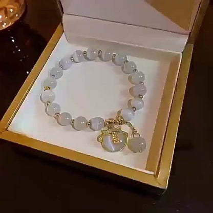 Sjika - Gold plated armband met kattenbedel & witte kralen – Uniek damesdesign – Schattig & elegant – Perfect cadeau voor haar