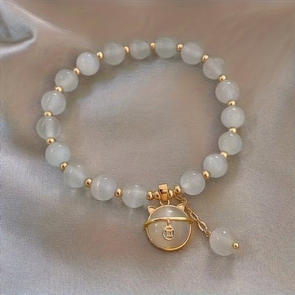 Sjika - Gold plated armband met kattenbedel & witte kralen – Uniek damesdesign – Schattig & elegant – Perfect cadeau voor haar