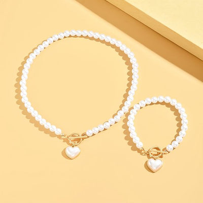 Sjika - Gold plated parelset met hart hanger – Luxe ketting & armband dames – Elegant & romantisch design – Perfect cadeau voor haar