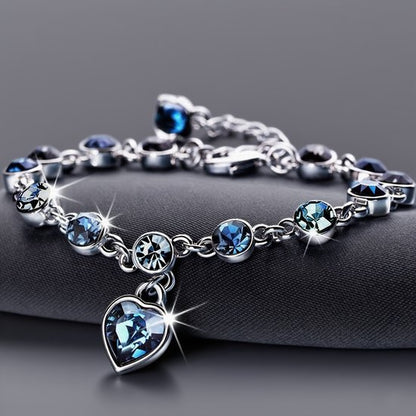 Sjika - Zilverkleurige armband met blauwe kristallen & hart hanger – Luxe damesarmband – Elegant & romantisch design – Perfect cadeau voor haar