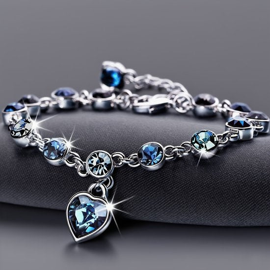Sjika - Zilverkleurige armband met blauwe kristallen & hart hanger – Luxe damesarmband – Elegant & romantisch design – Perfect cadeau voor haar