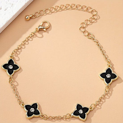 Sjika - Gold plated armband met zwarte klaver bloemen – Luxe damesarmband met kristalaccent – Trendy & Elegant sieraad – Perfect cadeau voor haar
