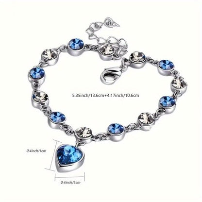 Sjika - Zilverkleurige armband met blauwe kristallen & hart hanger – Luxe damesarmband – Elegant & romantisch design – Perfect cadeau voor haar