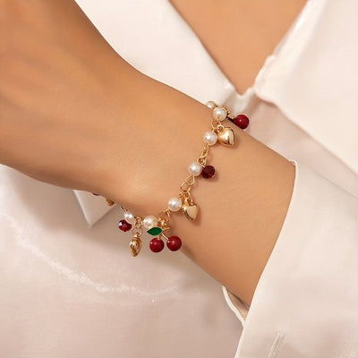Sjika - Gold plated armband met parels, hartjes & kersbedels – Trendy damesarmband – Speels & elegant design – Perfect cadeau voor haar