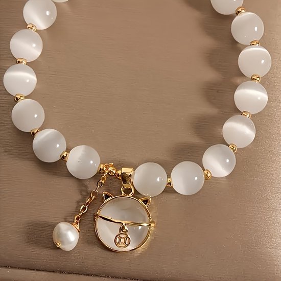 Sjika - Gold plated armband met kattenbedel & witte kralen – Uniek damesdesign – Schattig & elegant – Perfect cadeau voor haar